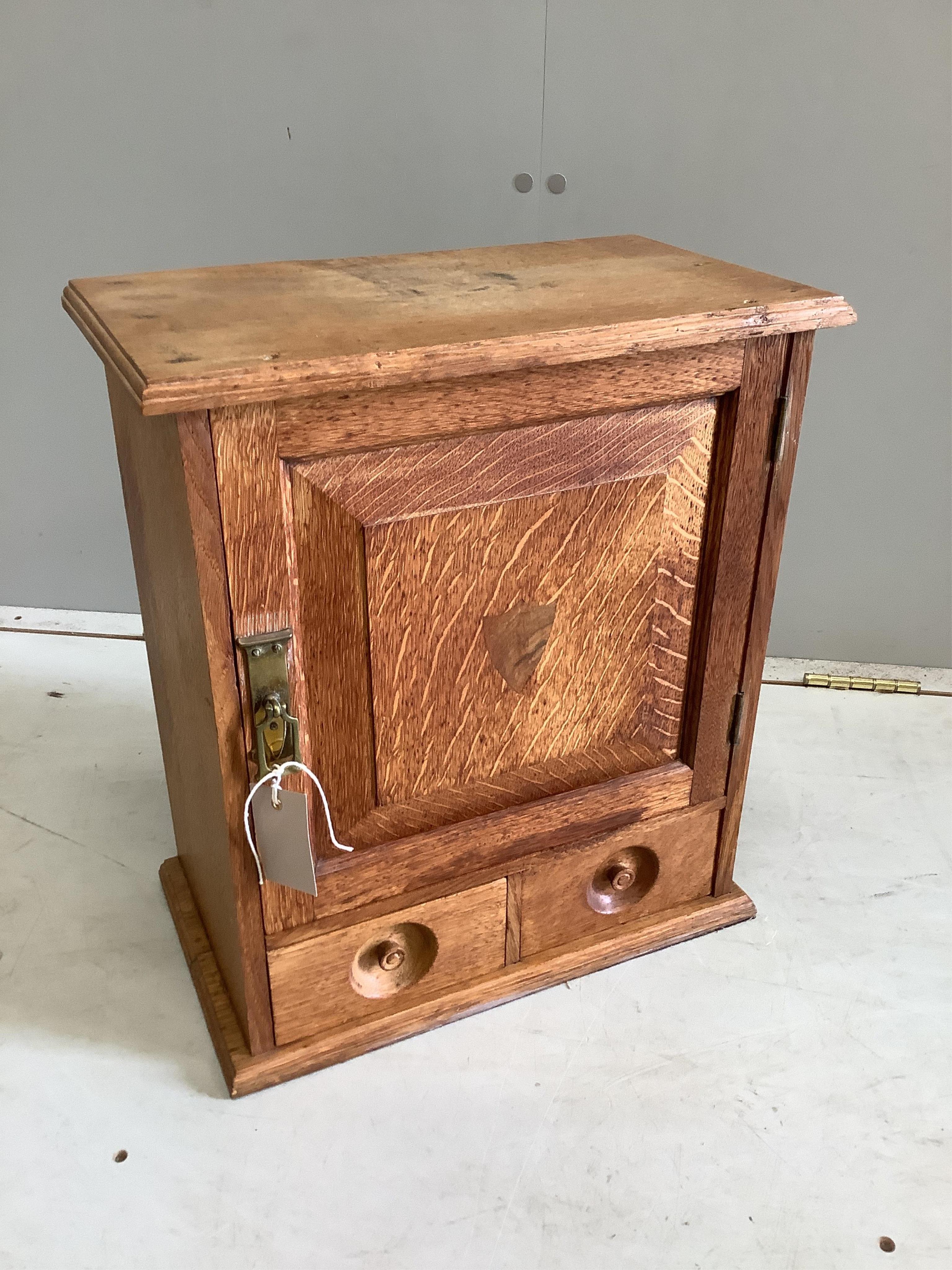 A late Victorian bleached oak two drawer smoker's cabinet, width 39cm, depth 22cm, height 45cm. Condition - fair